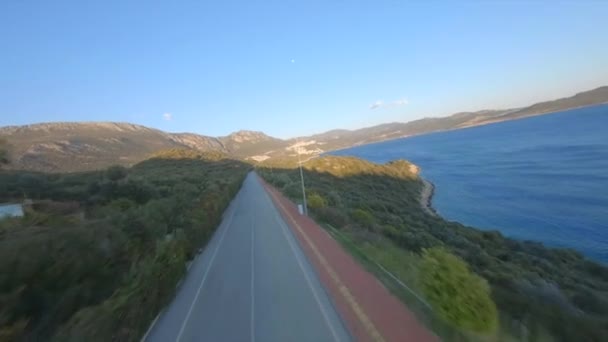 FPV Drone Shot Πάνω Ο δρόμος εκτείνεται κατά μήκος της χερσονήσου της ακτής πόλη Kas σε πανέμορφο ρύθμιση ένα όμορφο όρμο, γοητευτική φύση και τα βουνά στην Αττάλεια, Τουρκία. Αεροφωτογραφία. — Αρχείο Βίντεο