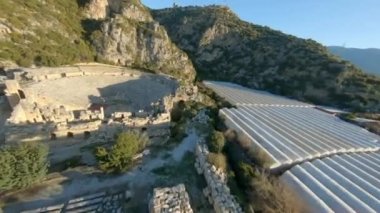 Fast Cinematic Drone Shot of ancient greek rock cut lykian empire amphitheatre and tombs in Myra, Demre, Turkey