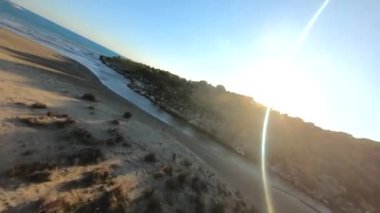 FPV Drone Cinematic Shot aerial waves and sandy beach at sunset time Near the Fisherman House on Lykian Way at the Demre beach. Extreve Aerobatics by Racing Drone.