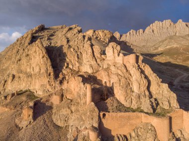 Eski Bayezid Cami ve Ishak Paşa Sarayı yakınlarındaki dağda inşa edilen Dogubayazit şatosunun harabelerinin fantastik dramatik hava manzarası. Doğu Türkiye