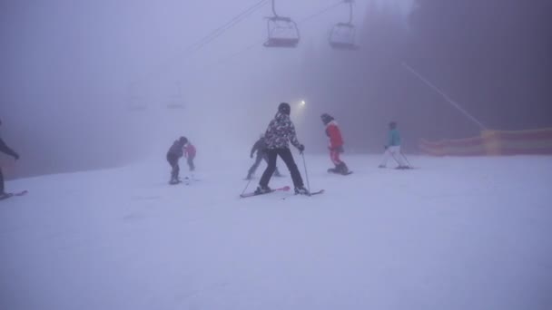 Bukovel, Ukraine - Dezember 2020: POV Abfahrt auf dem Snowboard, nebliges Gebiet in Höhenlagen Skigebiet. Ukrainisches Skigebiet in der Nebensaison, künstlicher Schnee, schlechte Sicht. — Stockvideo