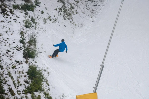 Snowboarder montando en nieve blanca cubierto pendiente vista superior — Foto de Stock