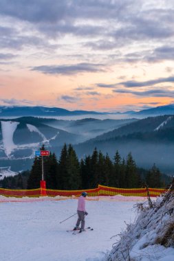 BUKOVEL, UKRAINE - Aralık 2020: insanlar Bukovel kayak merkezindeki yamaçtan aşağı iniyorlar. Bukovel, Ukrayna 'nın en popüler kayak merkezidir.
