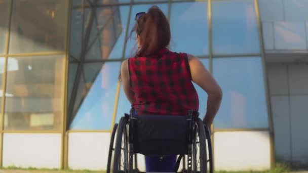 Glada söt flicka i rullstol i casual outfit är promenader vid Broadway i Sea Port i Odessa — Stockvideo