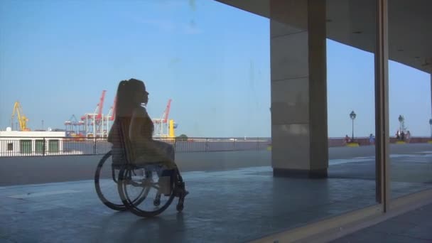 Веселая милая девушка в инвалидной коляске в повседневной одежде позирует в городской среде — стоковое видео