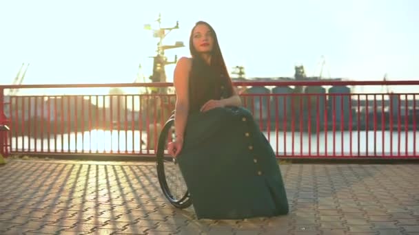 Glada söt flicka i rullstol i casual outfit poserar i stadsmiljön — Stockvideo