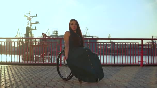 Fröhlich Nettes Mädchen im Rollstuhl im grünen Abendcocktailkleid genießt Sonnenuntergang in der städtischen Umgebung — Stockvideo