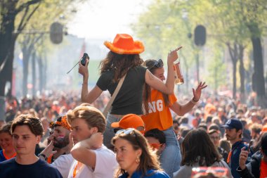 Amsterdam, Hollanda - Mayıs 2025: İnsanlar Krallar Günü 'nde Amsterdam kanalları tarafından turuncu botlarda yüzüyordu. Yüksek kalite fotoğraf