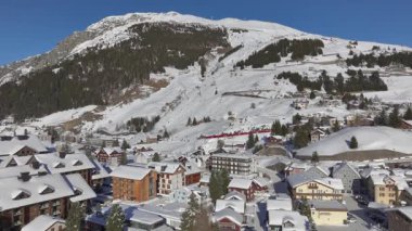 Andermatt, İsviçre, kışın. Kar yağdıktan sonra güneşli bir günde İsviçre 'nin Kanton Uri Alplerindeki dağ köyünün havası. Yüksek kalite 4k görüntü