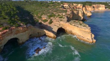 Marinha Sahili, Algarve, Güney Portekiz 'deki Doğal Kemer' in havadan görünüşü. Oyulmuş sahil şeridindeki kayalık yamaçlar. Yüksek kalite 4k görüntü