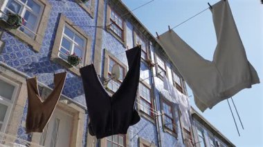 Porto 'da, Porto, Portekiz' in manzaralı caddelerinin yerel yeteneği Azulejo 'daki güzel bir fayanslı evin önünde asılı giysiler. Yüksek kalite 4k görüntü