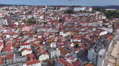 Turuncu çatıları, tarihi katedrali ve açık mavi gökyüzü altındaki eski binaları olan Coimbra şehri. Portekiz 'de havadan ateş edilmiş. Yüksek kalite 4k görüntü