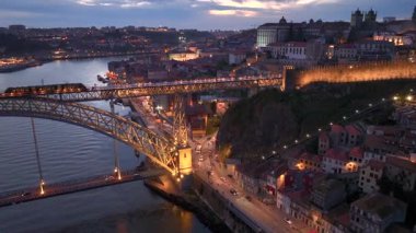 Douro nehri üzerindeki Dom Luis Köprüsü ile Porto Şehri 'ni aydınlattı. Gece Işıkları ve Altyapı Üzerine Hava Çekimi. Yüksek kalite 4k görüntü