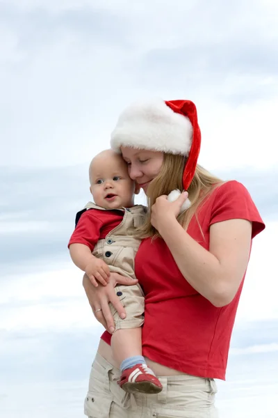 Young attractive mom with Santa's hat and the little baby