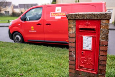 SwanSEA, WALES, İngiltere - 12 Aralık 2020: Mektuplar için kırmızı vintage posta kutusu ve Kraliyet Posta Minibüsü, İngiliz posta servisi ve kurye şirketi