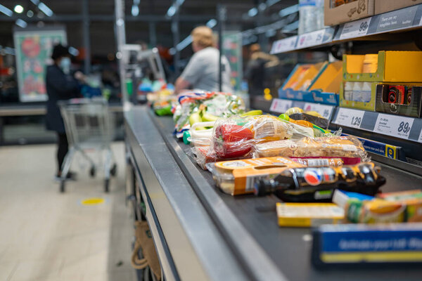Groceries shopping at Lidl, checkout cashier counter belt full of groceries at supermarket. Shopping with social distancing measures in stores. Wales, UK