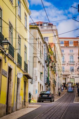 LISBON, PORTUGAL - 25 Mart 2017: Lizbon 'un eski renkli binaları, füniküler ve rayları olan eski güzel turistik caddesi.