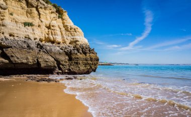 Cliffs of Praia da Dona Ana, sandy beach with clear blue water on a sunny day, no people, Lagos, Algarve, Portugal