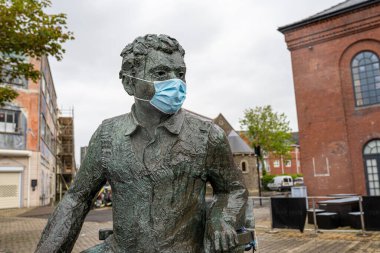 SwanSEA, İngiltere - 11 Temmuz 2021: Dylan Thomas heykeli yağmurlu bir günde Swansea, Galler 'de Covid maskesi takıyor. Galler 'de Coronavirus