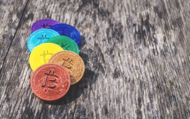 Gökkuşağı renginde renkli Bitcoin paralar yıpranmış ahşap üzerinde kopyalanmış boşluk