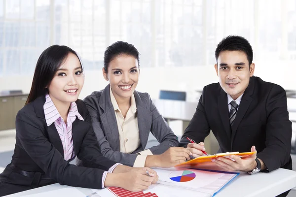 Equipe de negócios sentado no escritório e sorrindo — Fotografia de Stock