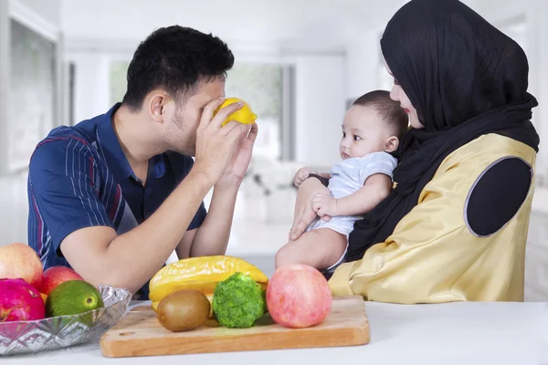 Papà gioca con il suo bambino usando frutta arancione — Foto Stock