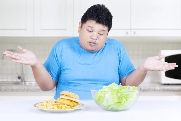 Dik persoon met salade en hamburger — Stockfoto