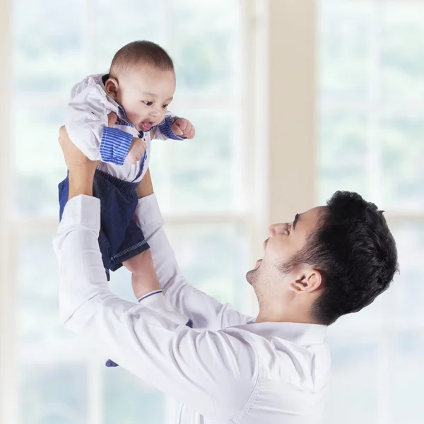 Feliz padre y bebé cerca de la ventana — Foto de Stock