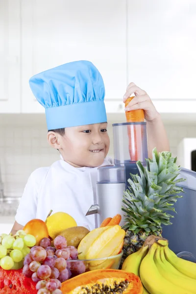 Kleine jongen maken van vers fruit sap — Stockfoto