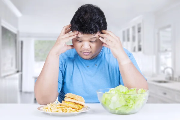 Overgewicht persoon met salade en hamburger — Stockfoto