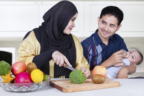 Dois pais e bebê fazendo comida saudável — Fotografia de Stock