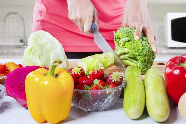 Woman hand cutting broccoli — Stock Photo, Image