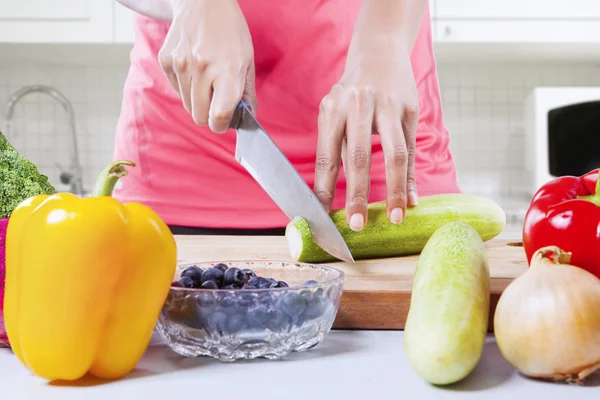 Frau schneidet Gurke von Hand — Stockfoto