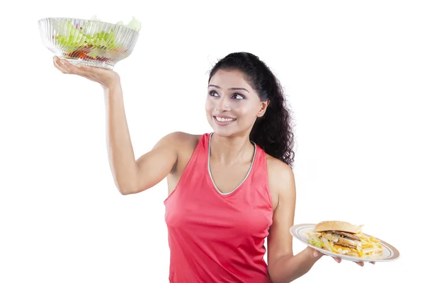 Mujer levantando comida saludable y comida rápida —  Fotos de Stock