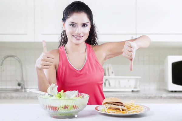 Mujer con buena y mala comida — Foto de Stock