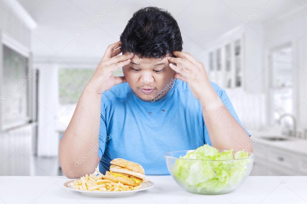 Overweight person with salad and hamburger
