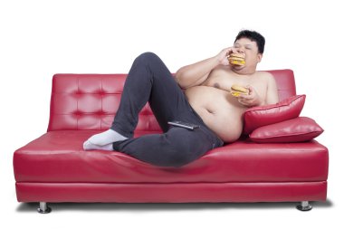 Obez adam kanepede iki hamburger yiyor