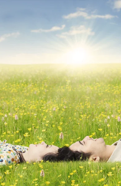 Paar liggen op het gras in de lente — Stockfoto