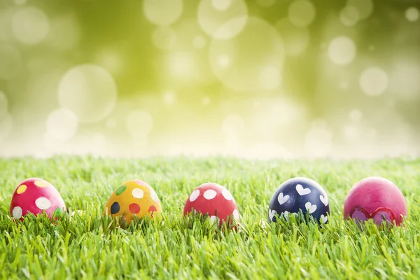 Uova di Pasqua su erba con sfondo bokeh — Foto Stock