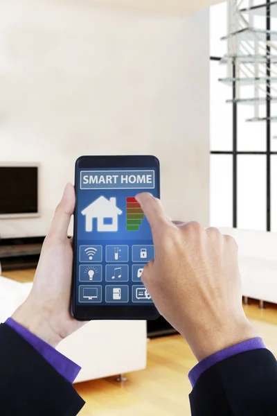 Hand using smartphone with smart house app — Stock Photo, Image