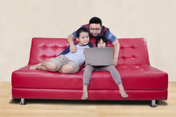 Gelukkige kinderen gebruiken laptop met papa — Stockfoto