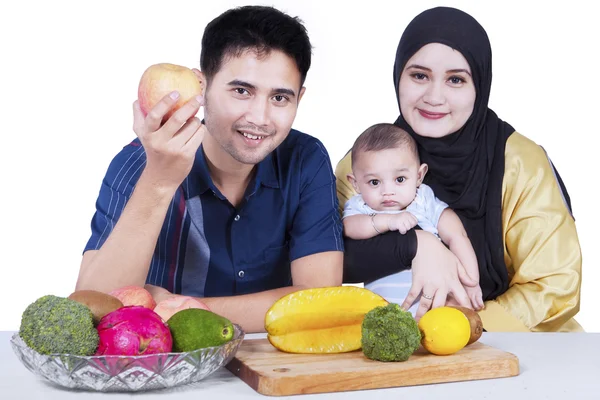 Família feliz com frutas na mesa — Fotografia de Stock