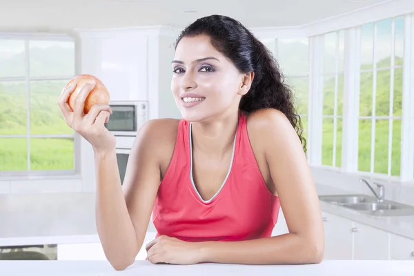 Счастливая женщина ест красное яблоко — стоковое фото