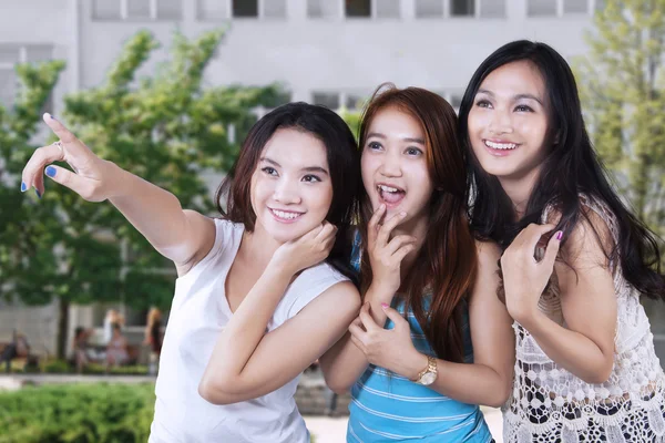Drie vrolijke vrouwelijke studenten op schoolplein — Stockfoto