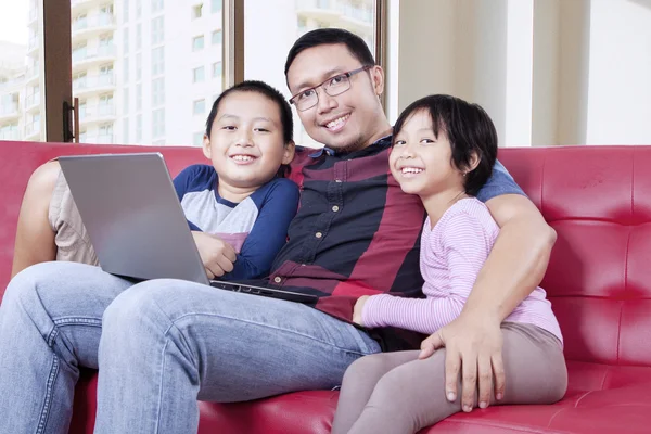 Två barn och pappa med laptop i lägenhet — Stockfoto