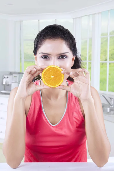 Mulher fechando sua boca com fatia de laranja — Fotografia de Stock