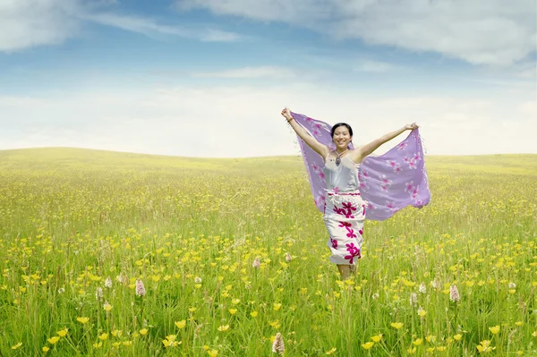 Jeune femme sur la prairie avec du tissu — Photo