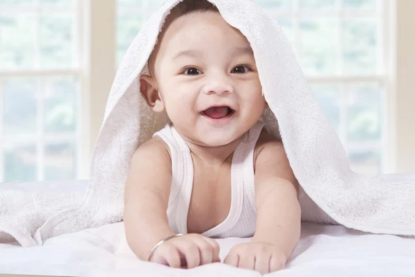 Entzückendes Kind mit einem Handtuch auf dem Bett — Stockfoto