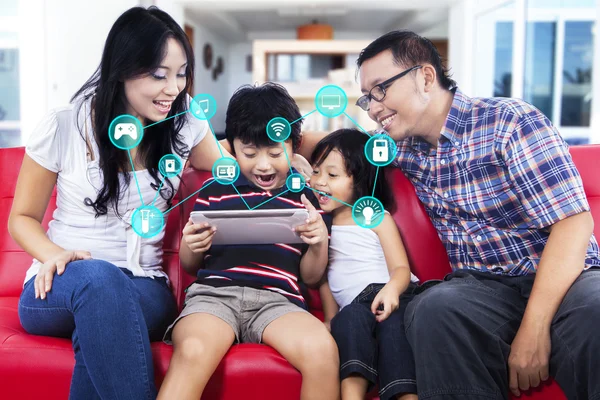 Família alegre com aplicativo casa inteligente no tablet — Fotografia de Stock