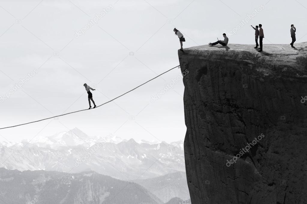 Businesspeople walking on the rope over the cliff